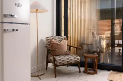 a room with a chair and a lamp and a table at Traditional Cornish Cottage & Garden Redruth in Redruth