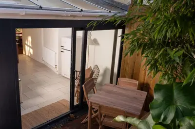 a patio with a wooden table and chairs at Traditional Cornish Cottage & Garden Redruth in Redruth