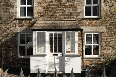 a white door on the side of a building at Traditional Cornish Cottage & Garden Redruth in Redruth