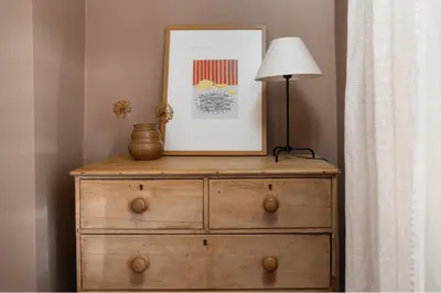 a wooden dresser with a lamp and a picture on it at Traditional Cornish Cottage & Garden Redruth in Redruth