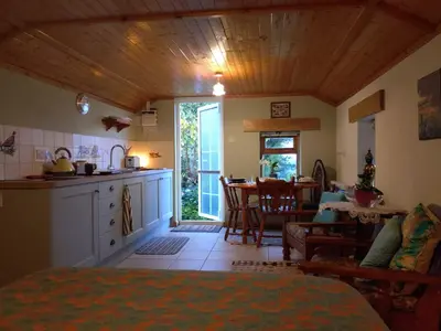 a room with a kitchen and a dining room with a table at The Haven in Trewen