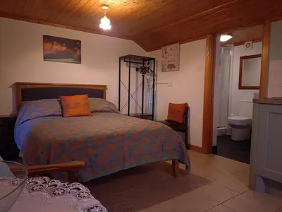 a bedroom with a bed and a bathroom at The Haven in Trewen