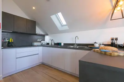 a kitchen with white cabinets and a sink at Sea Vista in Carbis Bay