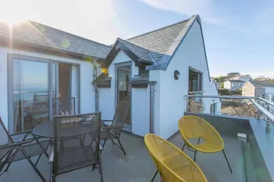 a patio with chairs and a table on a balcony at Sea Vista in Carbis Bay