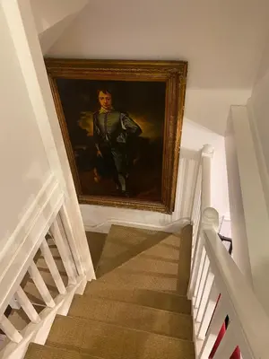 a painting of a man on a wall next to a staircase at Relaxing historic Roncon's Villa, The Paddock in Perranuthnoe