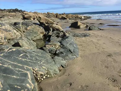 a group of rocks on a beach near the ocean at Relaxing historic Roncon's Villa, The Paddock in Perranuthnoe