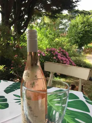 a bottle of wine sitting on a table with a glass at Relaxing historic Roncon's Villa, The Paddock in Perranuthnoe