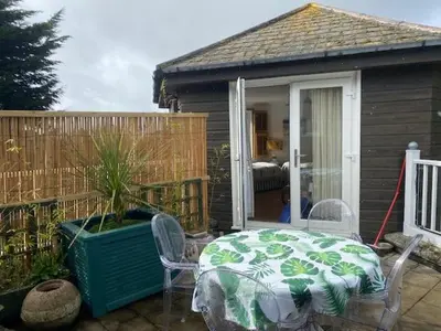 a patio with a table and chairs and a house at The Hexagon House in Penzance