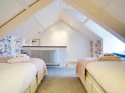 two beds in a room with an attic at Church Hill House in Port Isaac