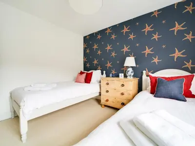 two beds in a bedroom with stars on the wall at Church Hill House in Port Isaac