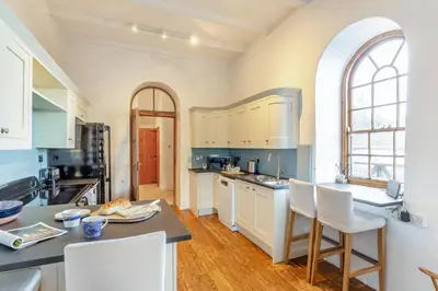 a kitchen with white cabinets and a table and chairs at 3 Bed in Porthtowan oc-e34620 in Porthtowan