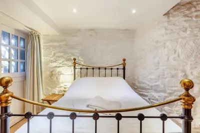 a bed in a bedroom with a stone wall at 3 Bed in Porthtowan oc-e34620 in Porthtowan