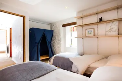 a bedroom with two beds and a blue curtain at 3 Bed in Porthtowan oc-e34620 in Porthtowan