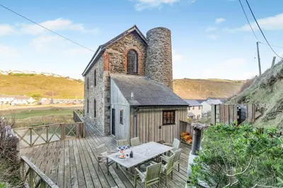 an old church with a table on a wooden deck at 3 Bed in Porthtowan oc-e34620 in Porthtowan