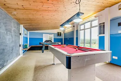 a pool table in a room with blue walls at 4 Bed in St. Gennys oc-p34626 in Crackington Haven
