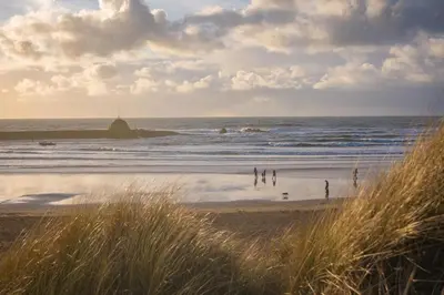 a group of people on a beach near the ocean at 4 Bed in St. Gennys oc-p34626 in Crackington Haven
