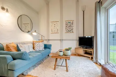 a living room with a blue couch and a tv at 1 Bed in St. Gennys oc-c34627 in Crackington Haven