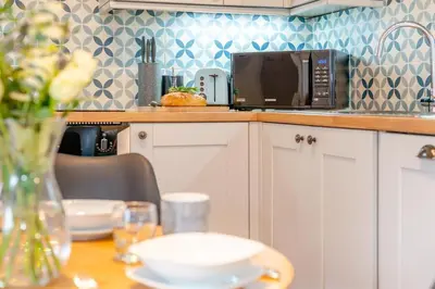 a kitchen with a table with a vase of flowers at 1 Bed in St. Gennys oc-c34627 in Crackington Haven