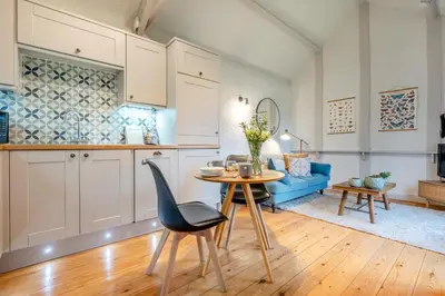a kitchen and living room with a table and a blue couch at 1 Bed in St. Gennys oc-c34627 in Crackington Haven