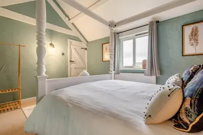 a bedroom with a white canopy bed and a window at 1 Bed in St. Gennys oc-c34627 in Crackington Haven