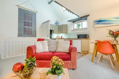 a living room with a red couch and a kitchen at 1 Bed in St. Gennys oc-l34629 in Crackington Haven
