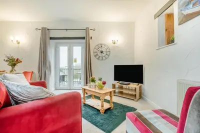 a living room with a red couch and a tv at 1 Bed in St. Gennys oc-l34629 in Crackington Haven