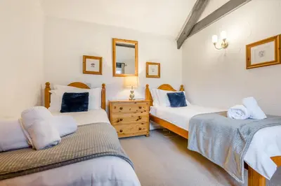 a bedroom with two beds and a mirror at 2 Bed in St. Gennys oc-o34630 in Crackington Haven