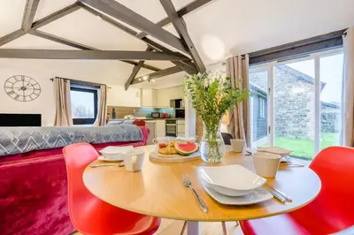 a dining room with a table and red chairs at 2 Bed in St. Gennys oc-o34630 in Crackington Haven