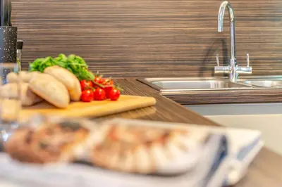 a counter with a cutting board with tomatoes and bread at 2 Bed in St. Gennys oc-o34630 in Crackington Haven