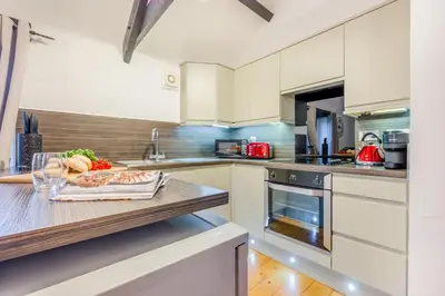 a kitchen with white cabinets and a wooden counter top at 2 Bed in St. Gennys oc-o34630 in Crackington Haven
