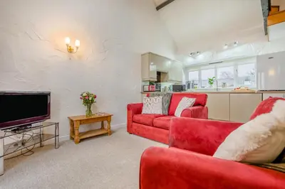 a living room with two red couches and a tv at 2 Bed in St. Gennys oc-p34632 in Crackington Haven