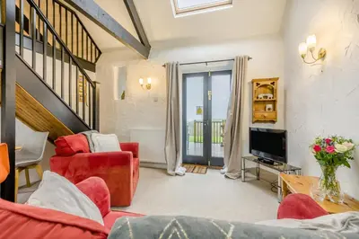 a living room with red furniture and a tv at 2 Bed in St. Gennys oc-p34632 in Crackington Haven
