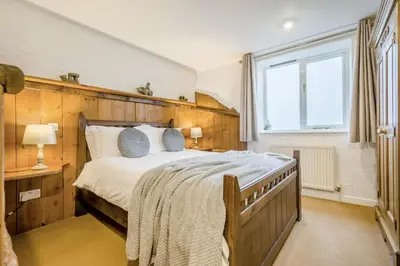 a bedroom with a large bed with a wooden headboard at 2 Bed in St. Gennys oc-p34632 in Crackington Haven