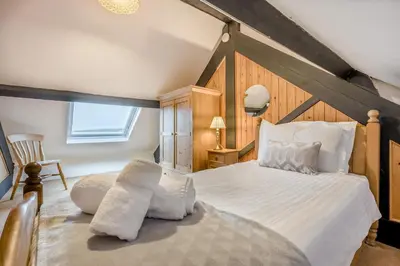a bedroom with a large bed in a attic at 3 Bed in St. Gennys oc-a34633 in Crackington Haven