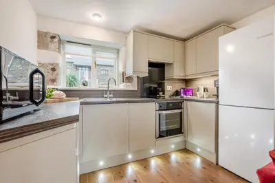 a kitchen with white cabinets and a refrigerator at 3 Bed in St. Gennys oc-a34633 in Crackington Haven