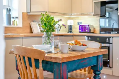 a table with bowls of food on it in a kitchen at 1 Bed in St. Gennys oc-v34634 in Crackington Haven