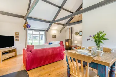 a living room with a red couch and a table at 1 Bed in St. Gennys oc-v34634 in Crackington Haven