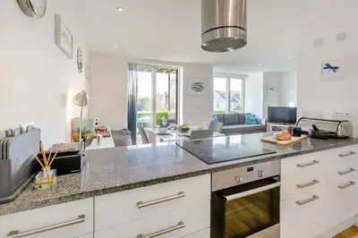 a kitchen with white cabinets and a living room at 2 Bed in St. Ives oc-t34467 in St Ives
