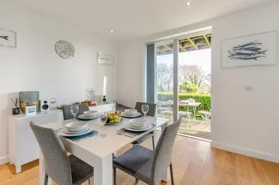 a white dining room with a white table and chairs at 2 Bed in St. Ives oc-t34467 in St Ives