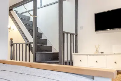 a living room with a tv and a staircase at 1 Bed in Looe oc-l30002 in Looe