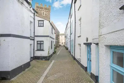 an alley with white buildings and a blue door at 1 Bed in Looe oc-l30002 in Looe