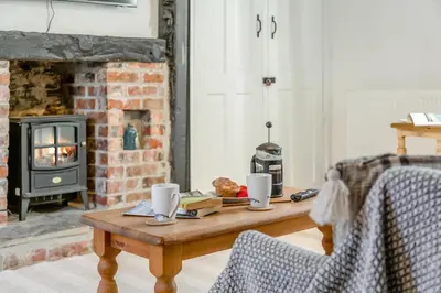 a coffee table in a living room with a fireplace at 1 Bed in Looe oc-l30002 in Looe