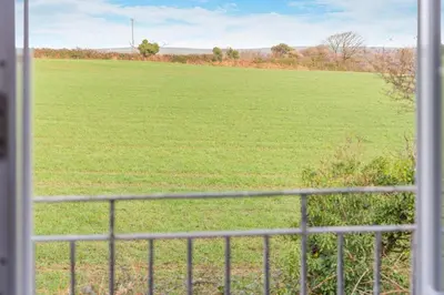a view of a large field from a window at 4 Bed in Newquay oc-s34623 in Saint Columb Major
