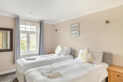 two beds in a room with a window at 4 Bed in Newquay oc-s34623 in Saint Columb Major