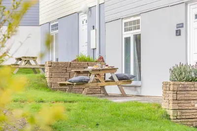 a picnic table on the side of a house at 4 Bed in Newquay oc-s34623 in Saint Columb Major