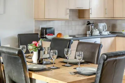 a dining room table with chairs and wine glasses at 4 Bed in Newquay oc-s34623 in Saint Columb Major