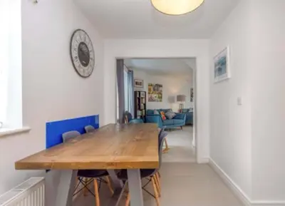 a dining room with a wooden table and chairs at Little Sea View Duporth - 3 bed, gated beach, Nr Eden Project in Charlestown