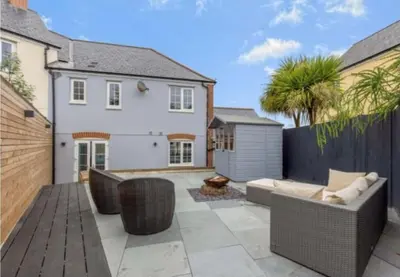 a patio with a couch and a fence at Little Sea View Duporth - 3 bed, gated beach, Nr Eden Project in Charlestown