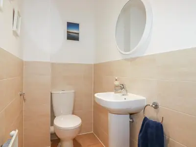 a bathroom with a toilet and a sink and a mirror at Blissful Ocean Breeze in Perranporth