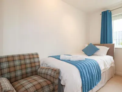 a bedroom with a bed and a chair at Blissful Ocean Breeze in Perranporth